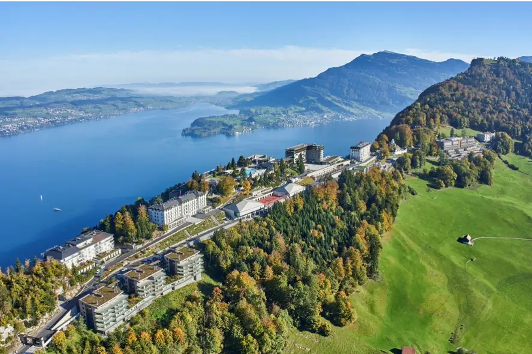Aerial view of a lakeside cliff-top resort in the Swiss Alps