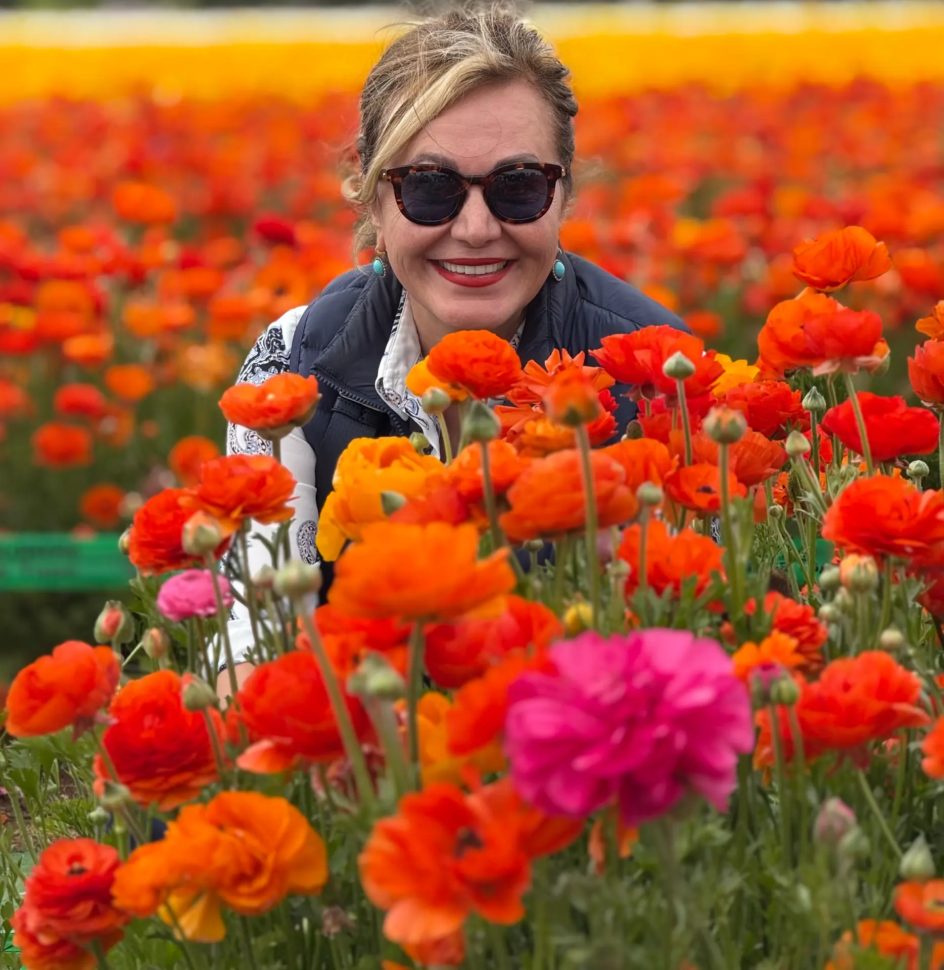 Farimah Parang, founder of GEM Hospitality Group, in a field of ranunculus flowers