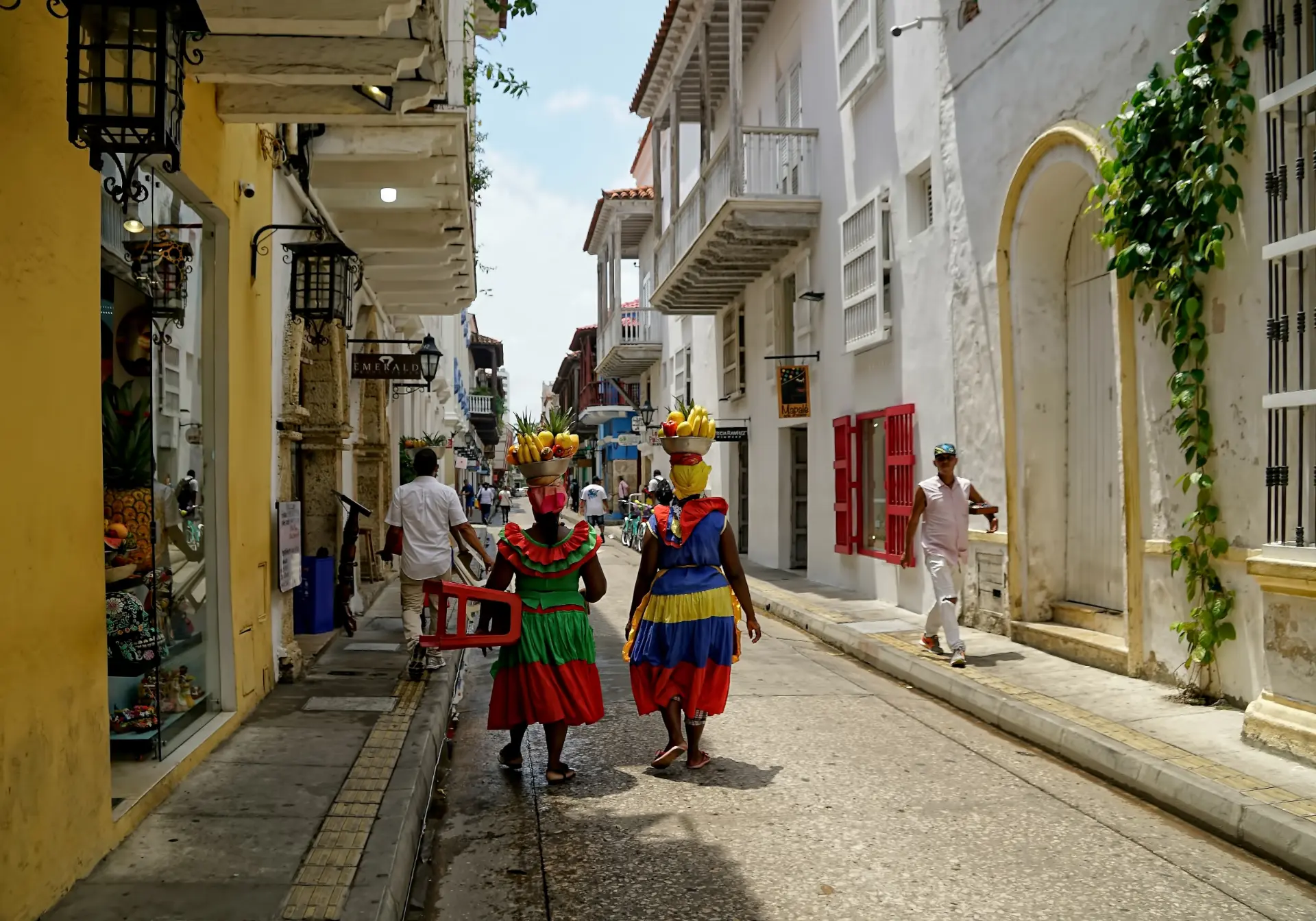 Palenquera fruit vendors walking a colonial street in Cartagena, Colombia